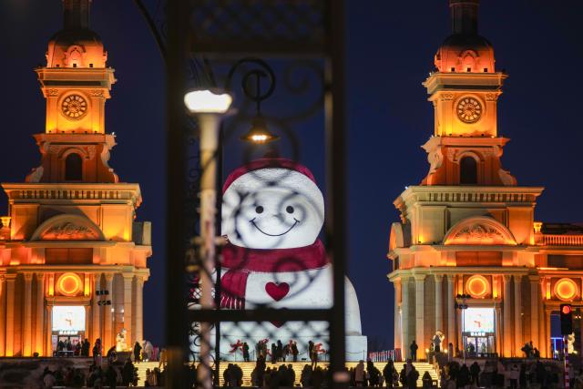 (260111) -- HARBIN, Jan. 11, 2026 (Xinhua) -- Tourists take photos of the iconic giant snowman at the Qunli music park in Harbin, northeast China's Heilongjiang Province, Jan. 10, 2026.
  Standing 19 meters tall, measuring 14 meters in length and 11 meters in width, the snowman was dug and carved out of over 3,500 cubic meters of snow, with tourists swarming to take pictures of its classic red scarf and round face. (Xinhua/Wang Jianwei)
