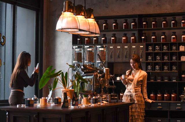 (260111) -- GUIYANG, Jan. 11, 2026 (Xinhua) -- People take photos at a coffee shop at a commercial complex in Guiyang, southwest China's Guizhou Province, Jan. 8, 2026.
  The city of Guiyang has been committed to the update and renovation of old commercial blocks, streets and factory areas. The renewed streets, such as Taiping, Minsheng, and Qingyun Roads have become vibrant spaces for relaxation and spending, driving urban consumption vitality and enhancing the city's youthful appeal. (Xinhua/Yang Wenbin)