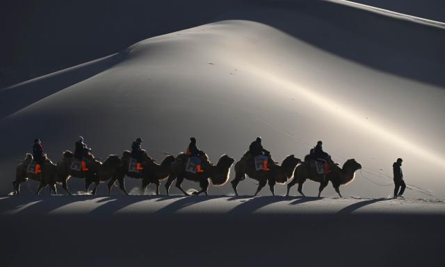 (260111) -- BEIJING, Jan. 11, 2026 (Xinhua) -- Tourists visit the Mingsha Mountain and Crescent Spring Scenic Area in Dunhuang City, northwest China's Gansu Province, Jan. 10, 2026. (Photo by Zhang Xiaoliang/Xinhua)