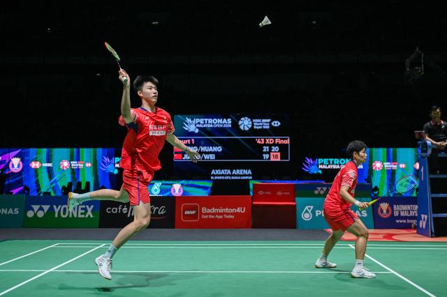 (260111) -- KUALA LUMPUR, Jan. 11, 2026 (Xinhua) -- Feng Yanzhe(L)/Huang Dongping of China compete during the mixed doubles final match against Jiang Zhenbang/Wei Yaxin of China at the Malaysia Open 2026 badminton tournament in Kuala Lumpur, Malaysia, Jan. 11, 2026. (Photo by Chong Voon Chung/Xinhua)