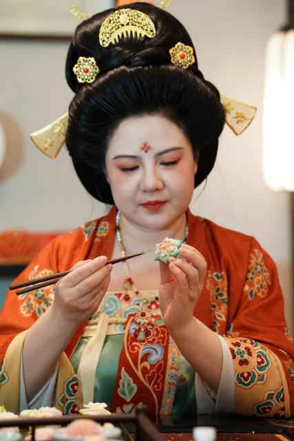 (260111) -- XI'AN, Jan. 11, 2026 (Xinhua) -- Li Huan makes a Tangguozi dessert in Xi'an, northwest China's Shaanxi Province, Jan. 9, 2026. Tangguozi, a sort of desserts inspired by the culture from the Tang Dynasty (618-907), features exquisite designs and vibrant colors, often served with tea. They are now going through a modern revival.
   Bearing years of experience in baking, Li Huan accidentally learned about Tangguozi and co-founded a company specialized in this business in 2020. Li believes that traditional culture is an inexhaustible source of creativity. She and her team often visit museums, drawing inspiration from the patterns and designs of artifacts from the Tang Dynasty. They carefully adjust the recipes by combining healthy diets with modern taste, which made their Tangguozi products increasingly popular.
    Li and her team have expanded their business approach by introducing Tangguozi and tea culture of the Tang Dynasty to domestic and international cultural exchange events, and hosting hands-on workshops for tourists and study groups. They also offer comprehensive services such as event planning and crafts training to make Tangguozi and the Tang culture more tangible and accessible to ordinary people. (Xinhua/Shao Rui)