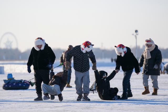 (260111) -- HARBIN, Jan. 11, 2026 (Xinhua) -- Tourists play on the frozen surface of the Songhua River in Harbin, northeast China's Heilongjiang Province, Jan. 10, 2026. The surface of the Harbin section of Songhua River, now solidly frozen, serves as a "fun field," where locals and tourists alike enjoy themselves with ice-and-snow-themed amusements. (Xinhua/Wang Jianwei)