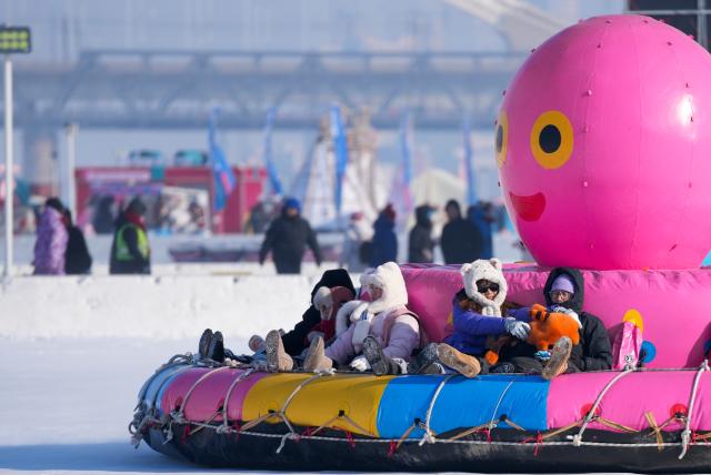 (260111) -- HARBIN, Jan. 11, 2026 (Xinhua) -- Tourists play on the frozen surface of the Songhua River in Harbin, northeast China's Heilongjiang Province, Jan. 11, 2026. The surface of the Harbin section of Songhua River, now solidly frozen, serves as a "fun field," where locals and tourists alike enjoy themselves with ice-and-snow-themed amusements. (Xinhua/Wang Jianwei)