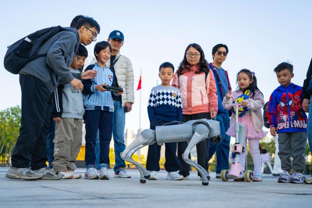 (260111) -- MACAO, Jan. 11, 2026 (Xinhua) -- A child learns to operate a robotic dog at the University of Macao in Macao, south China, Jan. 11, 2026. The launch ceremony for the celebrations of the 45th anniversary of the University of Macao, along with an open-day event, kicked off here on Sunday. (Xinhua/Cheong Kam Ka)