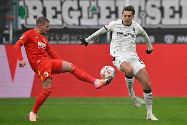 (260112) -- MOENCHENGLADBACH, Jan. 12, 2026 (Xinhua) -- Florian Neuhaus (R) of Borussia Moenchengladbach vies with Mads Pedersen of FC Augsburg during the German first division of Bundesliga football match between Borussia Moenchengladbach and FC Augsburg in Moenchengladbach, Germany, Jan. 11, 2026. (Photo by Ulrich Hufnagel/Xinhua)