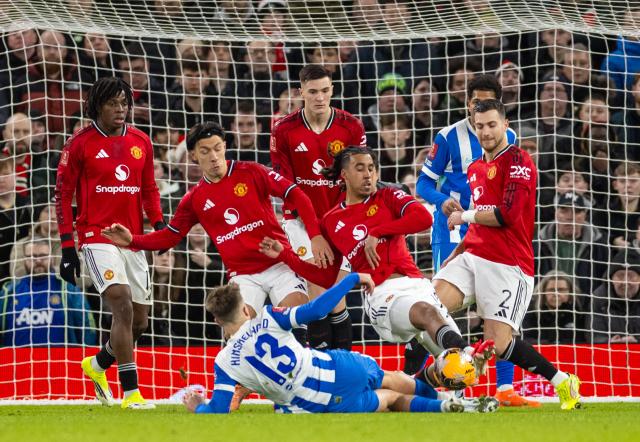 (260112) -- MANCHESTER, Jan. 12, 2026 (Xinhua) -- Five Manchester United's players challenge Brighton & Hove Albion's Jack Hinshelwood (bottom) during the FA Cup 3rd Round match between Manchester United FC and Brighton & Hove Albion FC in Manchester, Britain, on Jan. 11, 2026. FOR EDITORIAL USE ONLY. NOT FOR SALE FOR MARKETING OR ADVERTISING CAMPAIGNS. NO USE WITH UNAUTHORIZED AUDIO, VIDEO, DATA, FIXTURE LISTS, CLUB/LEAGUE LOGOS OR "LIVE" SERVICES. ONLINE IN-MATCH USE LIMITED TO 45 IMAGES, NO VIDEO EMULATION. NO USE IN BETTING, GAMES OR SINGLE CLUB/LEAGUE/PLAYER PUBLICATIONS. (Xinhua)