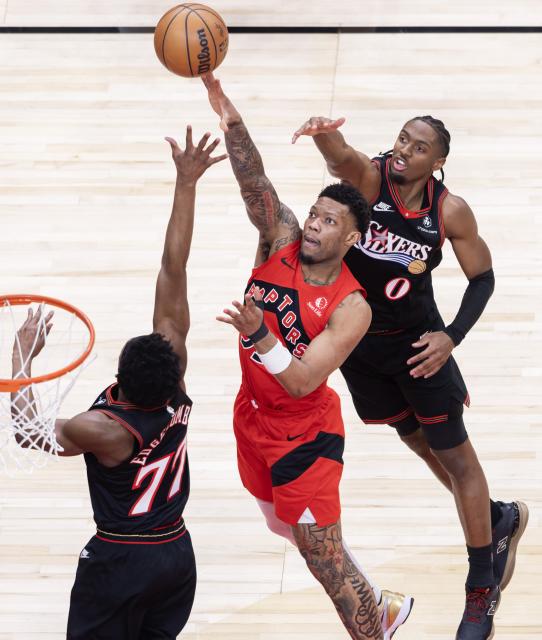 (260112) -- TORONTO, Jan. 12, 2026 (Xinhua) -- Alijah Martin (C) of Toronto Raptors goes for a layup during the 2025-2026 NBA regular season game between Toronto Raptors and Philadelphia 76ers in Toronto, Canada, on Jan. 11, 2026. (Photo by Zou Zheng/Xinhua)