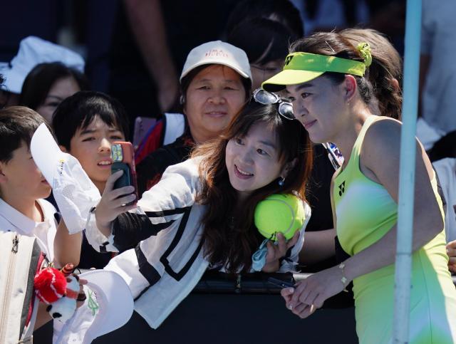 (260112) -- MELBOURNE, Jan. 12, 2026 (Xinhua) -- Zhu Lin (R) of China takes photos with fans after winning the women's singles qualifying 1st round match against Laura Pigossi of Brazil at Australian Open tennis tournament in Melbourne, Australia, Jan. 12, 2026. (Xinhua/Wang Shen)