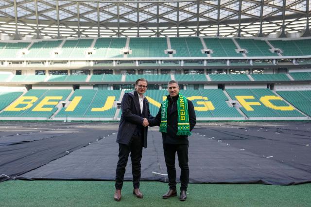 (260112) -- BEIJING, Jan. 12, 2026 (Xinhua) -- Matthias Brosamer (L), new sports general manager of Beijing Guoan Football Club, and Nick Montgomery, new head coach of Beijing Guoan, the Chinese Super League (CSL) club, shake hands at the Worker's Stadium in Beijing, capital of China, Jan. 12, 2026. (Xinhua/Ju Huanzong)