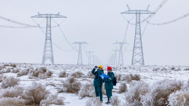 (260113) -- URUMQI, Jan. 13, 2026 (Xinhua) -- Staff members patrol a section of the Hami South-Zhengzhou ultra-high voltage direct current power transmission line in Yizhou District of Hami, northwest China's Xinjiang Uygur Autonomous Region, Jan. 10, 2026. (Photo by Zhang Lingjun/Xinhua)