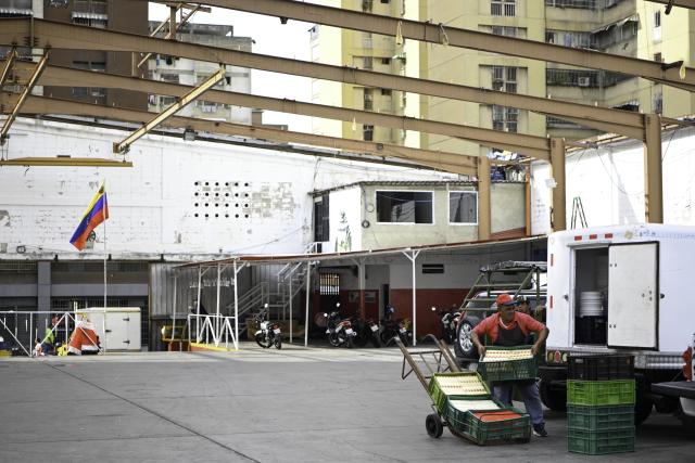 (260113) -- CARACAS, Jan. 13, 2026 (Xinhua) -- A man moves cheese at a cheese market in Caracas, Venezuela, Jan. 13, 2026. (Xinhua/Ding Hongfa)