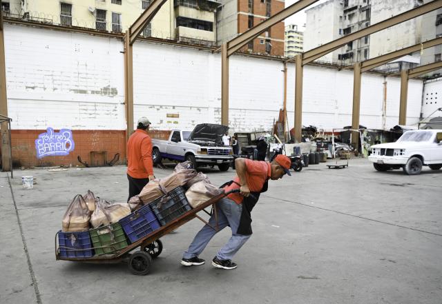 (260113) -- CARACAS, Jan. 13, 2026 (Xinhua) -- A man transport cheese at a cheese market in Caracas, Venezuela, Jan. 13, 2026. (Xinhua/Ding Hongfa)