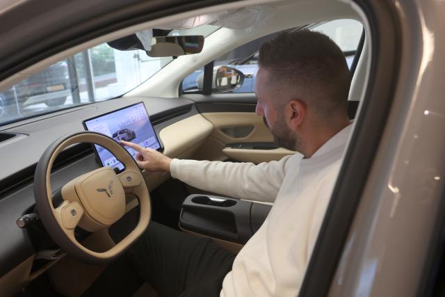(260113) -- TEL AVIV, Jan. 13, 2026 (Xinhua) -- A man checks out a new electric car model of luxury brand Hongqi of Chinese automaker FAW Group, in Tel Aviv, Israel, Jan. 13, 2026. Chinese automaker FAW Group on Monday launched a new electric car model of its luxury brand Hongqi in Israel, Hongqi's official importer and dealership Samelet said. (Photo by Gil Cohen Magen/Xinhua)