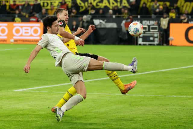 (260114) -- DORTMUND, Jan. 14, 2026 (Xinhua) -- Waldemar Anton (rear) of Borussia Dortmund vies with Sugawara Yukinari of SV Werder Bremen during the German first division Bundesliga football match between Borussia Dortmund and SV Werder Bremen in Dortmund, Germany, Jan. 13, 2026. (Photo by Joachim Bywaletz/Xinhua)