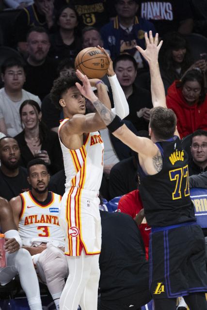 (260114) -- LOS ANGELES, Jan. 14, 2026 (Xinhua) -- Atlanta Hawks' Jalen Johnson (L) shoots against Los Angeles Lakers' Luka Doncic (R) during the 2025-2026 NBA regular season game between Los Angeles Lakers and Atlanta Hawks in, Los Angeles, the United States, on Jan. 13, 2026. (Photo by Ringo Chiu/Xinhua)