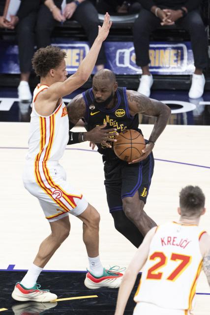 (260114) -- LOS ANGELES, Jan. 14, 2026 (Xinhua) -- Los Angeles Lakers' LeBron James (C) drives against Atlanta Hawks' Dyson Daniels (L) during the 2025-2026 NBA regular season game between Los Angeles Lakers and Atlanta Hawks in, Los Angeles, the United States, on Jan. 13, 2026. (Photo by Ringo Chiu/Xinhua)