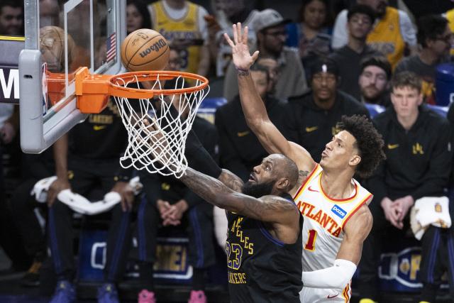 (260114) -- LOS ANGELES, Jan. 14, 2026 (Xinhua) -- Los Angeles Lakers' LeBron James (L) goes past Atlanta Hawks' Jalen Johnson to the basket during the 2025-2026 NBA regular season game between Los Angeles Lakers and Atlanta Hawks in, Los Angeles, the United States, on Jan. 13, 2026. (Photo by Ringo Chiu/Xinhua)