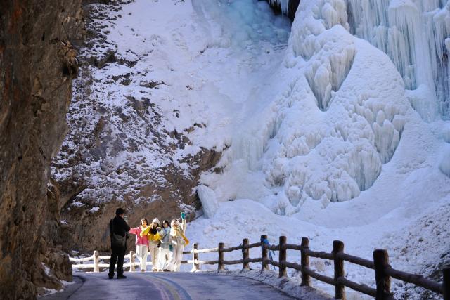 (260114) -- BEIJING, Jan. 14, 2026 (Xinhua) -- People pose for photos with ice cascade in the backdrop at Guan'egou scenic spot in Dangchang County, northwest China's Gansu Province, Jan. 9, 2026.
  China enters its coldest season in the eleventh month of the Chinese lunar calendar. 
  Urbanization and modern agriculture have weakened the impact of solar terms on daily life, but cultural and dietary habits have been passed down from generation to generation. (Photo by Liu Hui/Xinhua)