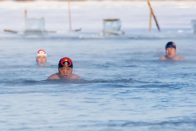 (260114) -- BEIJING, Jan. 14, 2026 (Xinhua) -- This photo taken on Jan. 13, 2026 shows winter swimming enthusiasts swimming in a river in Harbin, northeast China's Heilongjiang Province.
  China enters its coldest season in the eleventh month of the Chinese lunar calendar. Urbanization and modern agriculture have weakened the impact of solar terms on daily life, but cultural and dietary habits have been passed down from generation to generation. (Photo by Wang Yonggang/Xinhua)