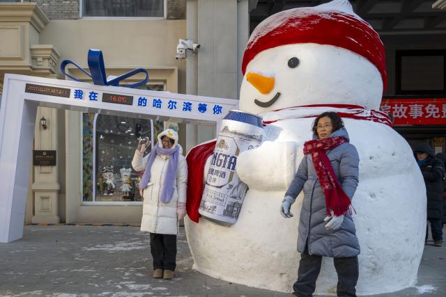 (260114) -- HARBIN, Jan. 14, 2026 (Xinhua) -- Tourists pose for photos at the Chinese Baroque Historic and Cultural Block in Harbin, northeast China's Heilongjiang Province, Jan. 14, 2026. Harbin is a major winter tourism destination in northeast China. The city's Chinese Baroque Historic and Cultural Block is attracting an increasing number of visitors. The century-old architectural complex, a fusion of Chinese and Western styles, displays a unique charm as the ice and snow season peaks. (Xinhua/Zhang Tao)