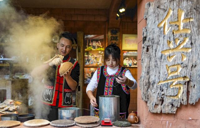 (260114) -- PU'ER, Jan. 14, 2026 (Xinhua) -- Villagers make Pu'er tea beverage at their tea store in Nakeli Village, in Hani and Yi Autonomous County of Ning'er, Pu'er City, southwest China's Yunnan Province on Jan. 14, 2026. The village of Nakeli, previously witnessed boisterous camel caravans carrying sacks of tea leaves while winding through ancient China's vast western area all the way to Southeast Asia and the Middle East. Today, the village has become a popular winter travel destination for tourists, thanks to its unique Tea Horse Road culture and pleasant climate. Besides visiting historical sites, tourists can also immerse themselves in activities such as making Pu'er tea products, retracing ancient paths on horseback, and tasting intangible cultural heritage cuisine. (Xinhua/Chen Xinbo)