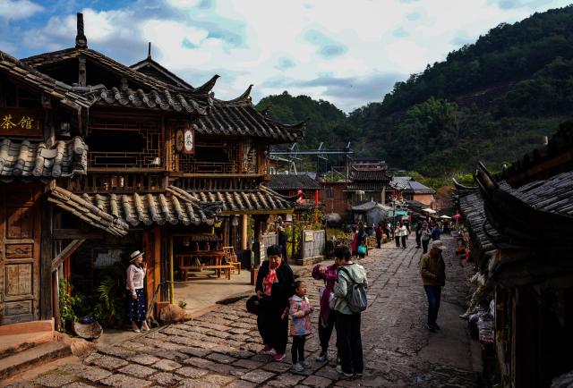 (260114) -- PU'ER, Jan. 14, 2026 (Xinhua) -- Tourists visit Nakeli Village, in Hani and Yi Autonomous County of Ning'er, Pu'er City, southwest China's Yunnan Province on Jan. 14, 2026. The village of Nakeli, previously witnessed boisterous camel caravans carrying sacks of tea leaves while winding through ancient China's vast western area all the way to Southeast Asia and the Middle East. Today, the village has become a popular winter travel destination for tourists, thanks to its unique Tea Horse Road culture and pleasant climate. Besides visiting historical sites, tourists can also immerse themselves in activities such as making Pu'er tea products, retracing ancient paths on horseback, and tasting intangible cultural heritage cuisine. (Xinhua/Chen Xinbo)