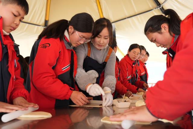 (260114) -- QUZHOU, Jan. 14, 2026 (Xinhua) -- Students enjoy a bread-making event during a study tour in Lulikeng Village of Changshan County, east China's Zhejiang Province, Jan. 14, 2026. Lulikeng Village has renovated its abandoned lime kilns into rural tourism facilities in recent years, turning the village into a destination for tourists from surrounding areas. Since 2024, various business sectors in the village have enabled over 150 villagers to find jobs right at their doorstep, and increased the village's income by more than 6 million yuan (about 0.86 million U.S. dollars). (Xinhua/Weng Xinyang)
