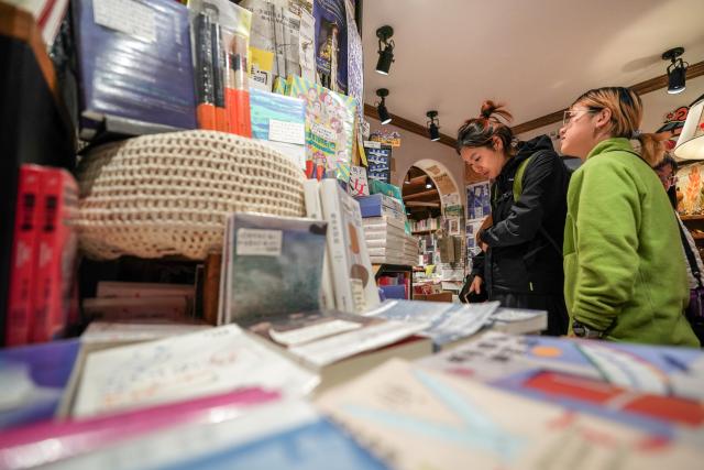(260114) -- KUNMING, Jan. 14, 2026 (Xinhua) -- Tourists visit a bookstore by Cuihu Lake in Kunming, southwest China's Yunnan Province, Jan. 13, 2026. Cuihu Lake is both a signature landscape of Kunming and a testament to the city's memories, surrounded by historical legacies such as the former sites of the National Southwestern Associated University and Yunnan Military Academy.
   Much like other older urban neighborhoods, the vicinity of Cuihu Lake had grappled with diminishing business vitality. The pressing challenge lies in revitalizing these dormant streets while preserving their historical essence and avoiding extensive demolition and construction.
   In recent years, a "cultural corridor" has been created around the lake, linking scattered historical and cultural sites while capitalizing on the thriving coffee industry. Cafe-centered boutique retail businesses have been established along this corridor, shaping an inclusive public space where people can feel free to take a walk, enjoy coffee and immerse themselves in reading. This endeavor has successfully infused the old neighborhoods with new waves of consumption. "Going to the Cuihu Lake for coffee" is now trending among local residents and tourists alike. (Xinhua/Peng Yikai)