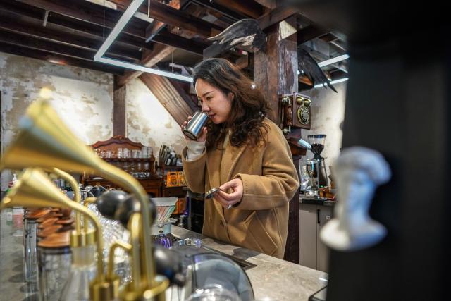 (260114) -- KUNMING, Jan. 14, 2026 (Xinhua) -- A staff member makes coffee for customers at a century-old coffee shop near Cuihu Lake in Kunming, southwest China's Yunnan Province, Jan. 13, 2026. Cuihu Lake is both a signature landscape of Kunming and a testament to the city's memories, surrounded by historical legacies such as the former sites of the National Southwestern Associated University and Yunnan Military Academy.
   Much like other older urban neighborhoods, the vicinity of Cuihu Lake had grappled with diminishing business vitality. The pressing challenge lies in revitalizing these dormant streets while preserving their historical essence and avoiding extensive demolition and construction.
   In recent years, a "cultural corridor" has been created around the lake, linking scattered historical and cultural sites while capitalizing on the thriving coffee industry. Cafe-centered boutique retail businesses have been established along this corridor, shaping an inclusive public space where people can feel free to take a walk, enjoy coffee and immerse themselves in reading. This endeavor has successfully infused the old neighborhoods with new waves of consumption. "Going to the Cuihu Lake for coffee" is now trending among local residents and tourists alike. (Xinhua/Peng Yikai)
