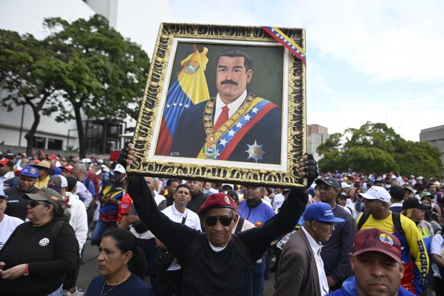 (260114) -- CARACAS, Jan. 14, 2026 (Xinhua) -- A man holding up a portrait of Nicolas Maduro participates in a march in Caracas, Venezuela, Jan. 14, 2026. Venezuelan workers participated in a march in Caracas on Wednesday demandeding that the U.S. government release Venezuelan President Nicolas Maduro and his wife. (Photo by Lucio Tavora/Xinhua)