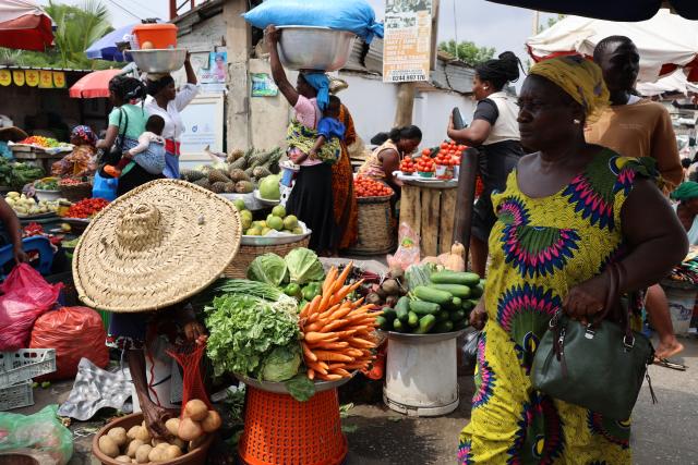 (260115) -- ACCRA, Jan. 15, 2026 (Xinhua) -- A woman walks past a vegetable stall at a street market in Accra, Ghana, on Jan. 14, 2026. (Photo by Seth/Xinhua)