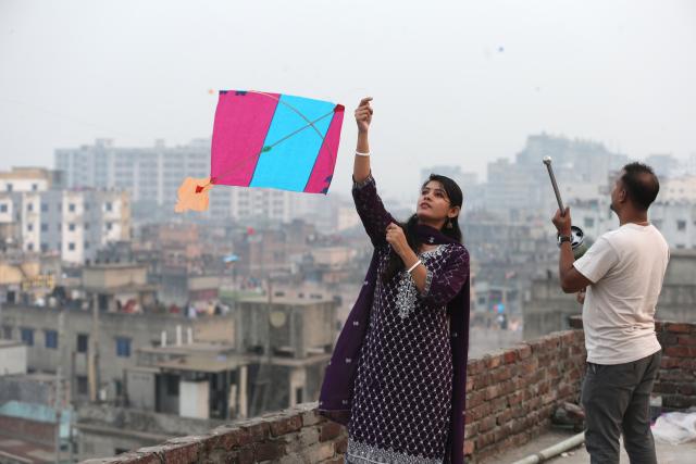 (260115) -- DHAKA, Jan. 15, 2026 (Xinhua) -- A woman flies a kite during the Sakrain festival in Dhaka, Bangladesh, Jan. 14, 2026. People in Dhaka celebrated Sakrain festival, also known as Ghuri Utsob or Kite festival, at the end of Poush, the ninth month of the Bengali calendar. (Photo by Habibur Rahman/Xinhua)