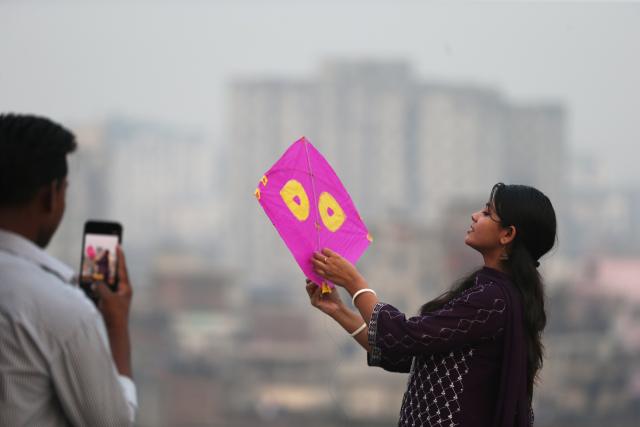 (260115) -- DHAKA, Jan. 15, 2026 (Xinhua) -- A woman holding a kite poses for a photo during the Sakrain festival in Dhaka, Bangladesh, Jan. 14, 2026. People in Dhaka celebrated Sakrain festival, also known as Ghuri Utsob or Kite festival, at the end of Poush, the ninth month of the Bengali calendar. (Photo by Habibur Rahman/Xinhua)