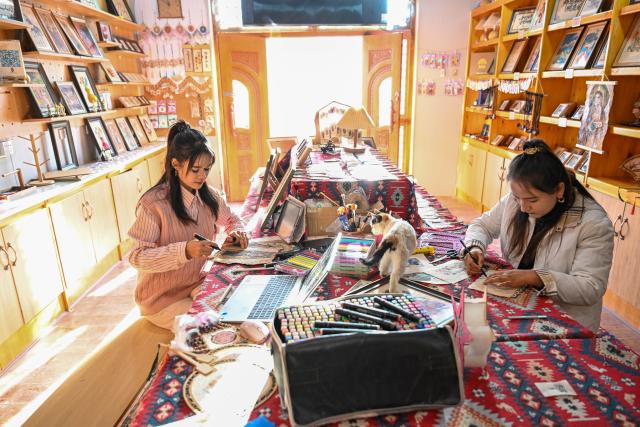 (260115) -- MOYU, Jan. 15, 2026 (Xinhua) -- Muyassar Ahmattohti (L) and her apprentice make cultural and creative products of mulberry paper at a mulberry paper industrial park in Moyu County, northwest China's Xinjiang Uygur Autonomous Region, on Jan. 13, 2026. Muyassar Ahmattohti, who graduated from Xinjiang Arts University in 2025, returned to her hometown and became a designer of cultural and creative products of mulberry paper, a national intangible cultural heritage with a history of over a thousand years.
   A mulberry paper cultural industrial park was built and put into operation in Moyu County in 2025, which integrates cultural display, creative incubation and tourism, providing a brand-new platform for the inheritance of mulberry paper. 
   In the industrial park, Muyassar has her own space for creation on mulberry paper, and meanwhile, by shooting short videos and other means, she is able to bring the mulberry paper into the view of more people.
   Muyassar's design inspiration comes from the natural elements around her and the traditional culture of her hometown. In her hands, this ancient craftsmanship is no longer staying silent but has been transformed into wearable patterns, light installations, and other companions for people. 
   "Every time the brush touches the mulberry paper, I can feel that I have connected the past and future of my hometown," said Muyassar. (Xinhua/Ding Lei)