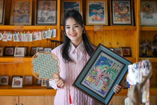 (260115) -- MOYU, Jan. 15, 2026 (Xinhua) -- Muyassar Ahmattohti shows her mulberry paper products at a mulberry paper industrial park in Moyu County, northwest China's Xinjiang Uygur Autonomous Region, on Jan. 13, 2026. Muyassar Ahmattohti, who graduated from Xinjiang Arts University in 2025, returned to her hometown and became a designer of cultural and creative products of mulberry paper, a national intangible cultural heritage with a history of over a thousand years.
   A mulberry paper cultural industrial park was built and put into operation in Moyu County in 2025, which integrates cultural display, creative incubation and tourism, providing a brand-new platform for the inheritance of mulberry paper. 
   In the industrial park, Muyassar has her own space for creation on mulberry paper, and meanwhile, by shooting short videos and other means, she is able to bring the mulberry paper into the view of more people.
   Muyassar's design inspiration comes from the natural elements around her and the traditional culture of her hometown. In her hands, this ancient craftsmanship is no longer staying silent but has been transformed into wearable patterns, light installations, and other companions for people. 
   "Every time the brush touches the mulberry paper, I can feel that I have connected the past and future of my hometown," said Muyassar. (Xinhua/Ding Lei)