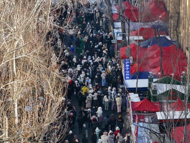 (260115) -- HARBIN, Jan. 15, 2026 (Xinhua) -- This aerial drone photo taken on Jan. 14, 2026 shows a bustling morning market in Harbin, northeast China's Heilongjiang Province. In winter, morning markets across Heilongjiang would open amid temperatures reaching minus 20 or even 30 degrees Celsius. Local residents and tourists stroll amid the stalls, where steam would rise among the cold air. (Photo by Zhang Shu/Xinhua)