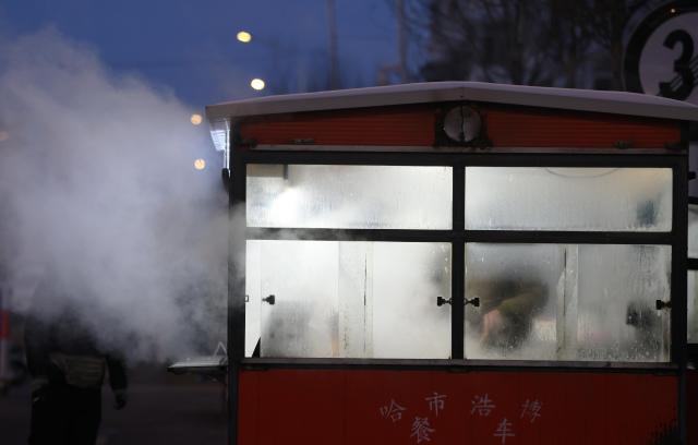 (260115) -- HARBIN, Jan. 15, 2026 (Xinhua) -- A breakfast stall is seen at a morning market in Harbin, northeast China's Heilongjiang Province, Jan. 14, 2026. In winter, morning markets across Heilongjiang would open amid temperatures reaching minus 20 or even 30 degrees Celsius. Local residents and tourists stroll amid the stalls, where steam would rise among the cold air. (Photo by Zhang Shu/Xinhua)