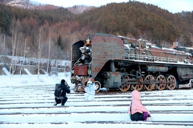 (260115) -- HAILIN, Jan. 15, 2026 (Xinhua) -- Tourists take photos at the Chinese Eastern Railway museum in Hengdaohezi Town of Hailin City, northeast China's Heilongjiang Province, Jan. 15, 2025. Dubbed "a town pulled by trains," Hengdaohezi was originally established in the late 19th century when Russians built train maintenance workshops and other facilities there following the construction of the Chinese Eastern Railway. Due to well-preserved historic buildings, the exotic town now has become a popular tourist destination. (Xinhua/Yang Zhe)