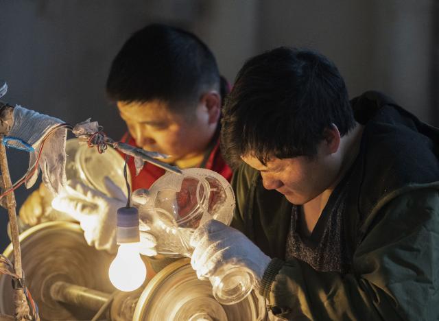 (260115) -- TIANCHANG, Jan. 15, 2026 (Xinhua) -- Workers make hookahs in Shiliang Town of Tianchang City, east China's Anhui Province, Jan. 14, 2026. In recent years, Shiliang has leveraged its traditional foundation in the art glass industry to develop a distinctive hookah production sector. The hookahs produced are primarily for export, reaching markets in the Middle East, Europe and other regions. (Xinhua/Du Yu)