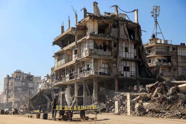 (260115) -- GAZA, Jan. 15, 2026 (Xinhua) -- Photo taken on Jan. 15, 2026 shows vendors near damaged buildings in Gaza City. (Photo by Rizek Abdeljawad/Xinhua)