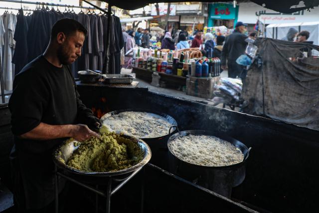 (260115) -- GAZA, Jan. 15, 2026 (Xinhua) -- A vendor prepares food in a market in Gaza City, Jan. 15, 2026. (Photo by Rizek Abdeljawad/Xinhua)