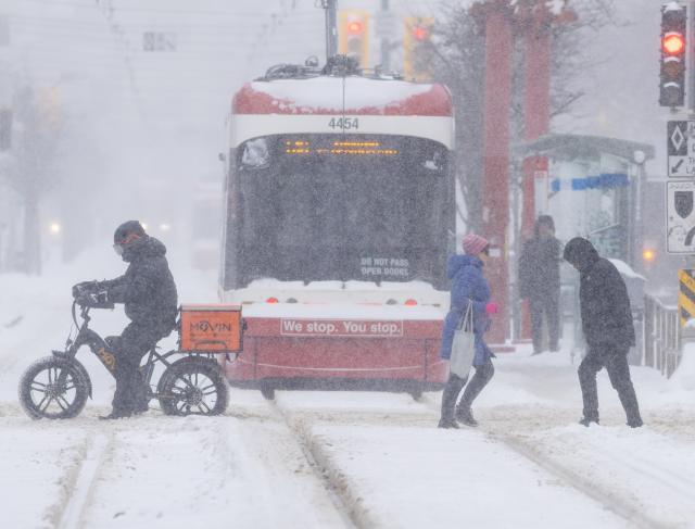 (260115) -- TORONTO, Jan. 15, 2026 (Xinhua) -- People cross a street during a snowy day in Toronto, Canada, on Jan. 15, 2026. (Photo by Zou Zheng/Xinhua)