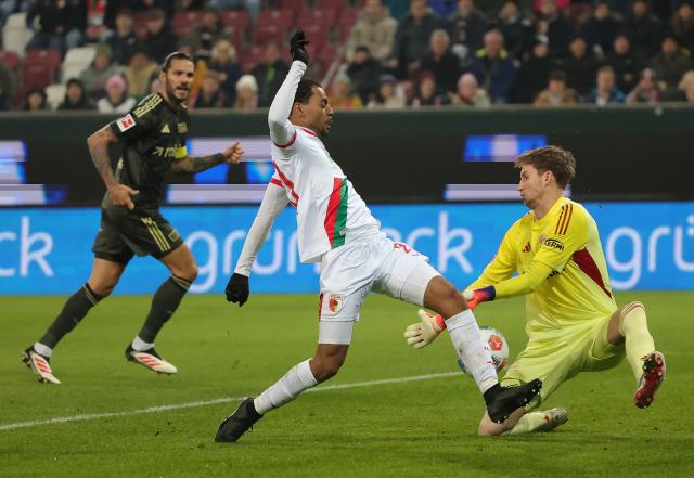 (251216) -- AUGSBURG, Dec. 16, 2025 (Xinhua) -- Goalkeeper of 1. FC Union Berlin Frederik Roennow (R) defends Alexis Claude-Maurice (C) of FC Augsburg during the German first division Bundesliga football match between FC Augsburg and 1. FC Union Berlin in Augsburg, Germany, Jan. 15, 2026. (Photo by Philippe Ruiz/Xinhua)