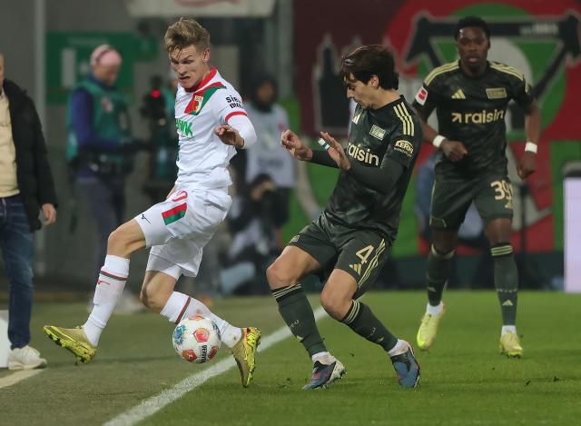 (251216) -- AUGSBURG, Dec. 16, 2025 (Xinhua) -- Anton Kade (L) of FC Augsburg vies with Diogo Leite (C) of 1. FC Union Berlin during the German first division Bundesliga football match between FC Augsburg and 1. FC Union Berlin in Augsburg, Germany, Jan. 15, 2026. (Photo by Philippe Ruiz/Xinhua)