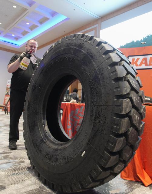 (260116) -- VANCOUVER, Jan. 16, 2026 (Xinhua) -- An exhibitor prepares a heavy-duty logging truck tire for display during the 2026 Truck Loggers Association Convention and Trade Show in Vancouver, British Columbia, Canada, Jan. 15, 2026. (Photo by Liang Sen/Xinhua)