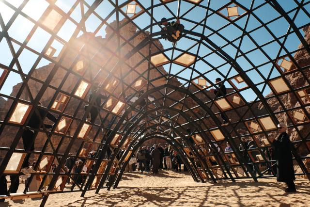 (260116) -- ALULA, Jan. 16, 2026 (Xinhua) -- People enjoy performance in front of an artwork exhibited during a preview of the art exhibition Desert X AlUla held in AlUla, Saudi Arabia, Jan. 15, 2026. Running from Jan. 16 to Feb. 28, Desert X AlUla opens its fourth edition here on Friday, showcasing 11 site-responsive artworks across valleys, canyons, and oases under the theme "Space Without Measure." (Xinhua/Xin Mengchen)