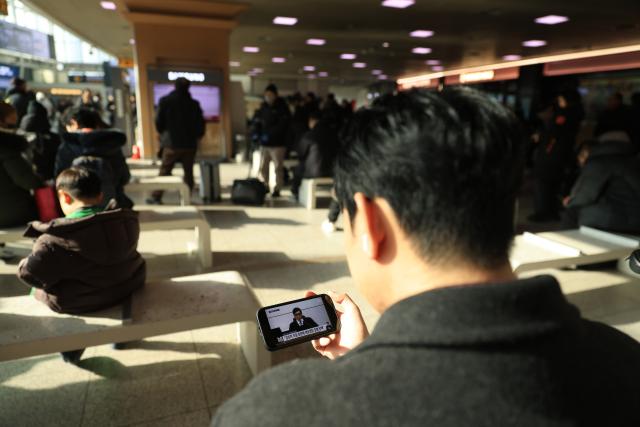 (260116) -- SEOUL, Jan. 16, 2026 (Xinhua) -- People watch a televised news report on Yoon Suk-yeol's court trial at Seoul Railway Station in Seoul, South Korea, on Jan. 16, 2026. South Korea's former impeached President Yoon Suk-yeol was sentenced to five years in prison on arrest obstruction charges, live footage showed Friday. (Photo by Park Jintaek/Xinhua)