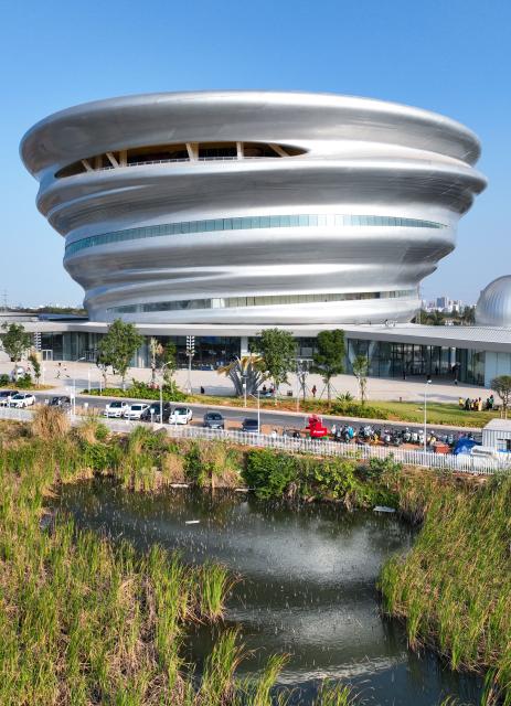 (260116) -- HAIKOU, Jan. 16, 2026 (Xinhua) -- A drone photo taken on Jan. 15, 2026 shows an exterior view of the Hainan Science and Technology Museum in Haikou, south China's Hainan Province. The Hainan Science and Technology Museum has recently kicked off trial operation, drawing numerous families and science fans to explore the immersive and hands-on exhibits there.
   A brand-new landmark for science popularization in the Hainan Free Trade Port, the museum in a spiraling "auspicious cloud" design boasts a total construction area of approximately 46,500 square meters. It highlights Hainan's advantages in innovation, showcases local technological achievements, and reflects the integration of ecology and technology. (Xinhua/Zhang Liyun)