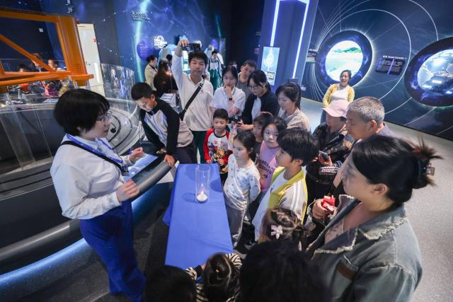(260116) -- HAIKOU, Jan. 16, 2026 (Xinhua) -- A staff member demonstrates a simple science experiment at the Hainan Science and Technology Museum in Haikou, south China's Hainan Province, Jan. 15, 2026. The Hainan Science and Technology Museum has recently kicked off trial operation, drawing numerous families and science fans to explore the immersive and hands-on exhibits there.
   A brand-new landmark for science popularization in the Hainan Free Trade Port, the museum in a spiraling "auspicious cloud" design boasts a total construction area of approximately 46,500 square meters. It highlights Hainan's advantages in innovation, showcases local technological achievements, and reflects the integration of ecology and technology. (Xinhua/Zhang Liyun)