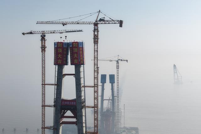 (260116) -- HAIYAN, Jan. 16, 2026 (Xinhua) -- A drone photo taken on Jan. 16, 2026 shows the topped-out No. 8 main tower (L) of the northern navigation channel bridge along the Hangzhou Bay Cross-Sea Railway Bridge in east China's Zhejiang Province. The 200-meter-high No. 8 main tower of the northern navigation channel bridge along the Hangzhou Bay Cross-Sea Railway Bridge was topped out on Friday.
   The 29.2-km-long Hangzhou Bay Cross-Sea Railway Bridge, which is a crucial segment of the Nantong-Suzhou-Jiaxing-Ningbo High Speed Railway, consists of three navigation channel bridges and 26-km-long approach bridges, and adopts a ballastless double-track design, with a designed top speed of 350 kilometers per hour. (Xinhua/Huang Zongzhi)
